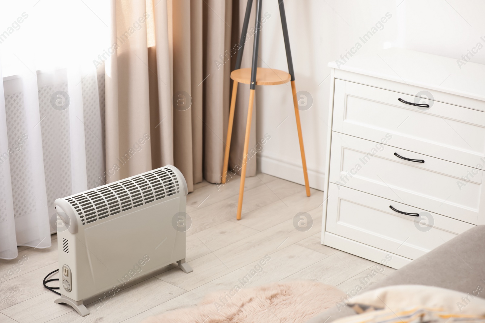 Photo of Modern electric heater in stylish room interior