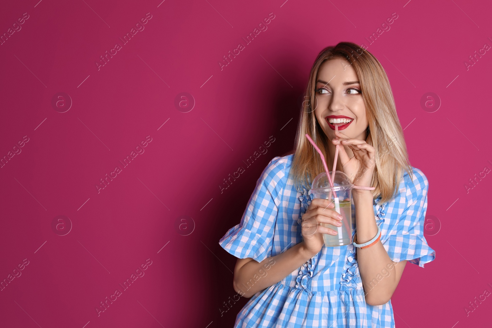 Photo of Young woman with tasty lemonade on color background. Natural detox drink