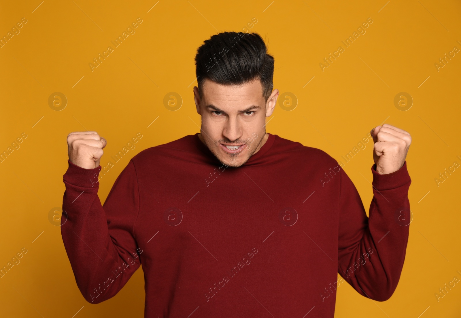 Photo of Angry man on yellow background. Hate concept