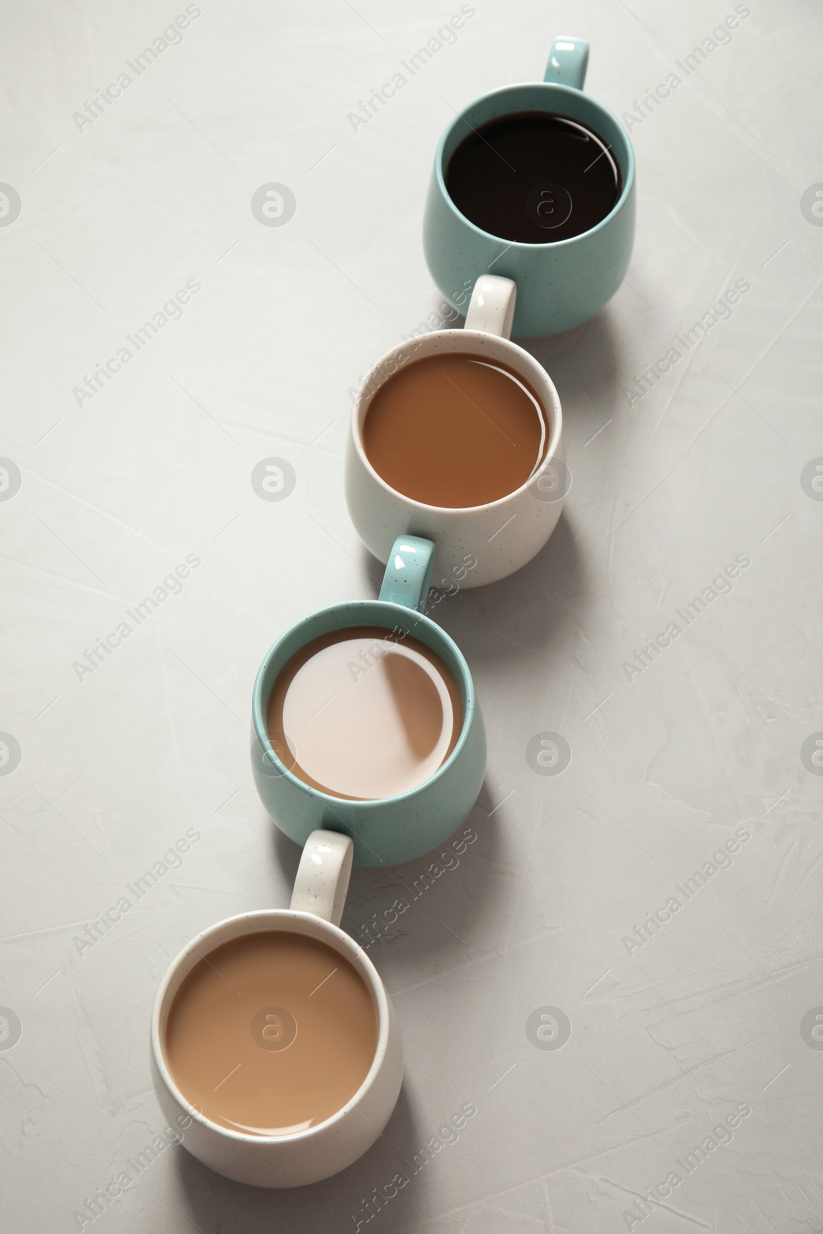 Photo of Cups of fresh aromatic coffee on gray background. Food photography