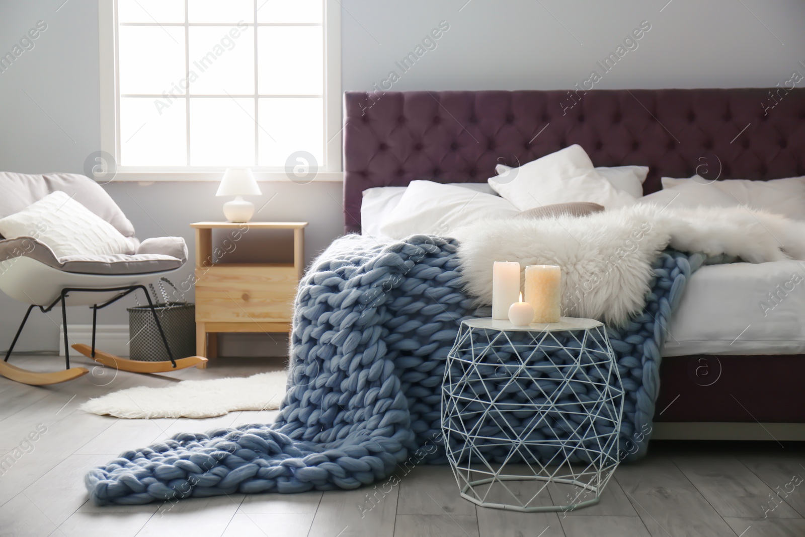 Photo of Stylish room interior with comfortable bed and rocking chair