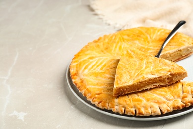 Photo of Traditional galette des rois on light grey marble table. Space for text