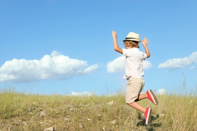 Photo of Cute little boy having fun outdoors, space for text. Child spending time in nature