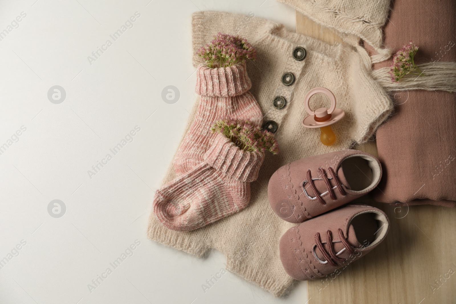 Photo of Baby clothes, shoes and accessories on light background, flat lay. Space for text