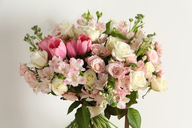 Photo of Beautiful bouquet of fresh flowers near white wall