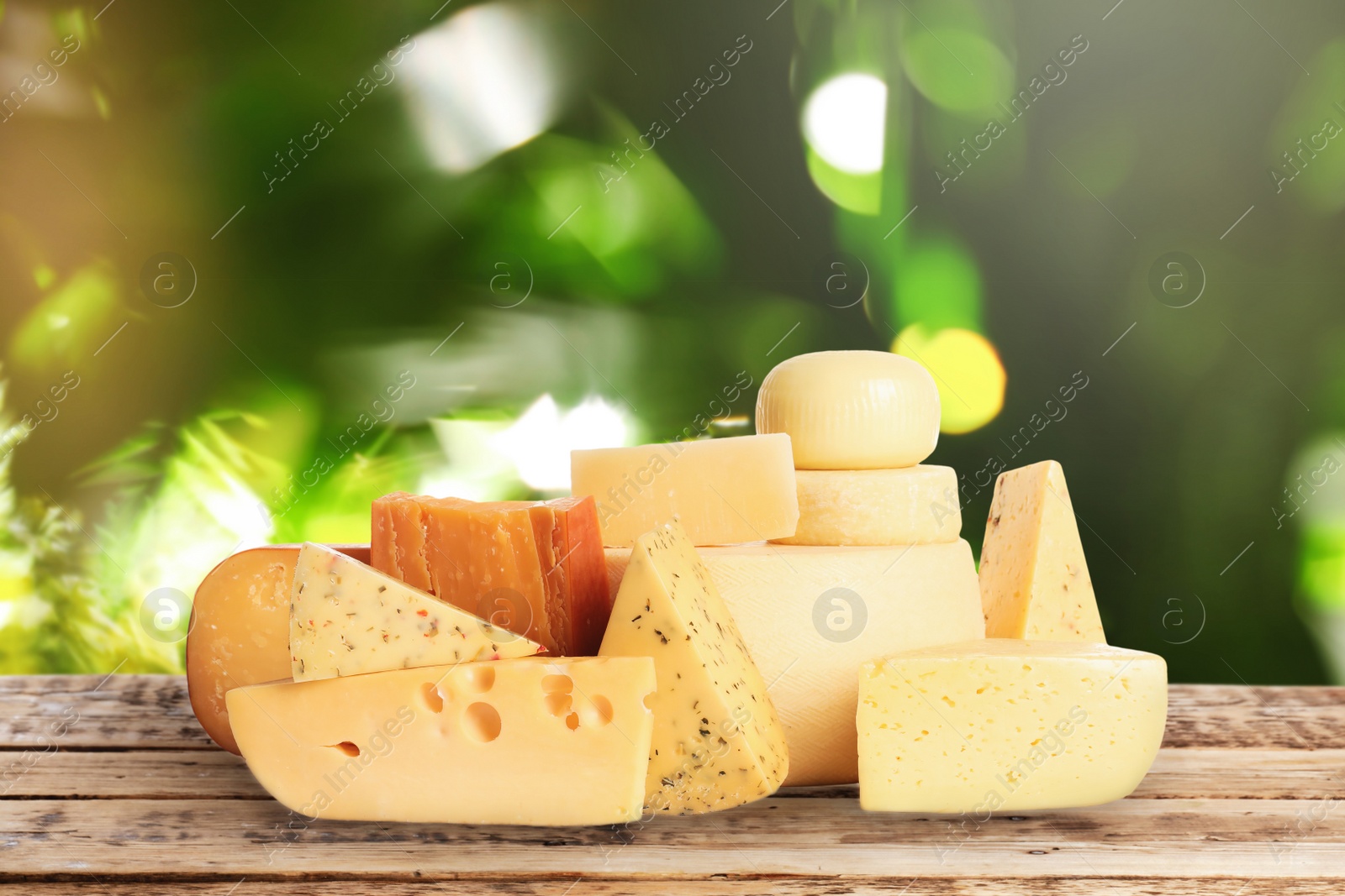 Image of Different types of delicious cheeses on wooden table outdoors. Dairy products