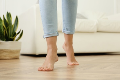Photo of Woman walking barefoot at home, closeup. Floor heating concept