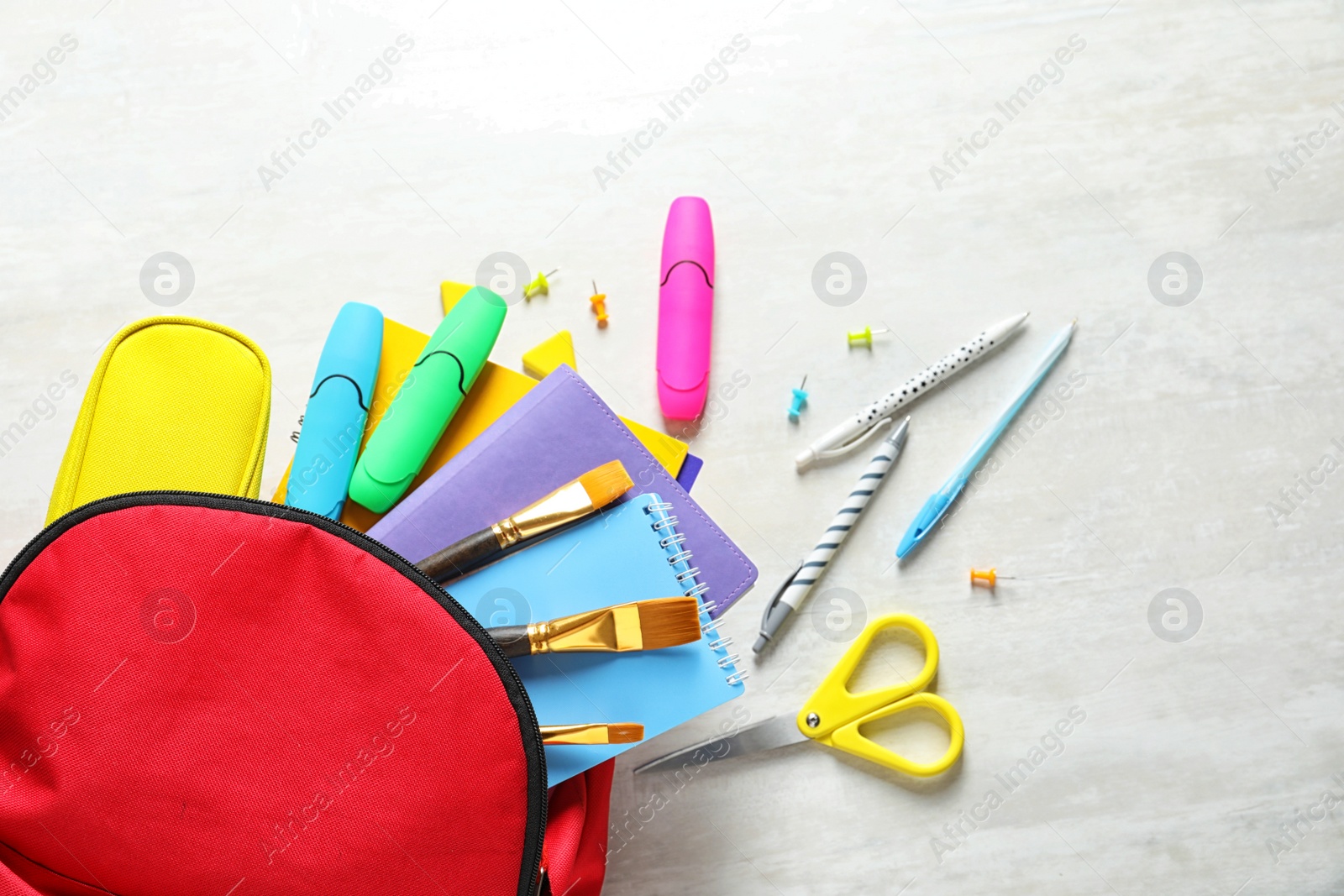Photo of Flat lay composition with backpack and school stationery on light background