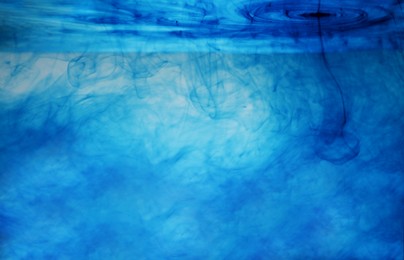 Liquid with bright blue paint as background