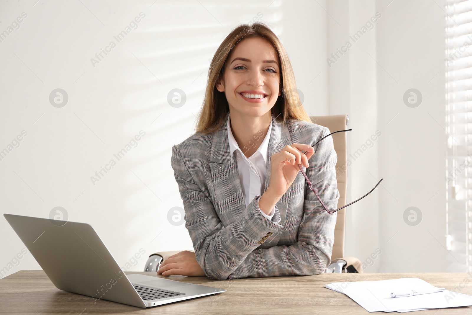 Photo of Portrait of beautiful young businesswoman with laptop at table in office