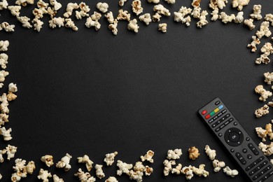 Photo of Frame made of popcorn and modern tv remote control on black background, flat lay. Space for text