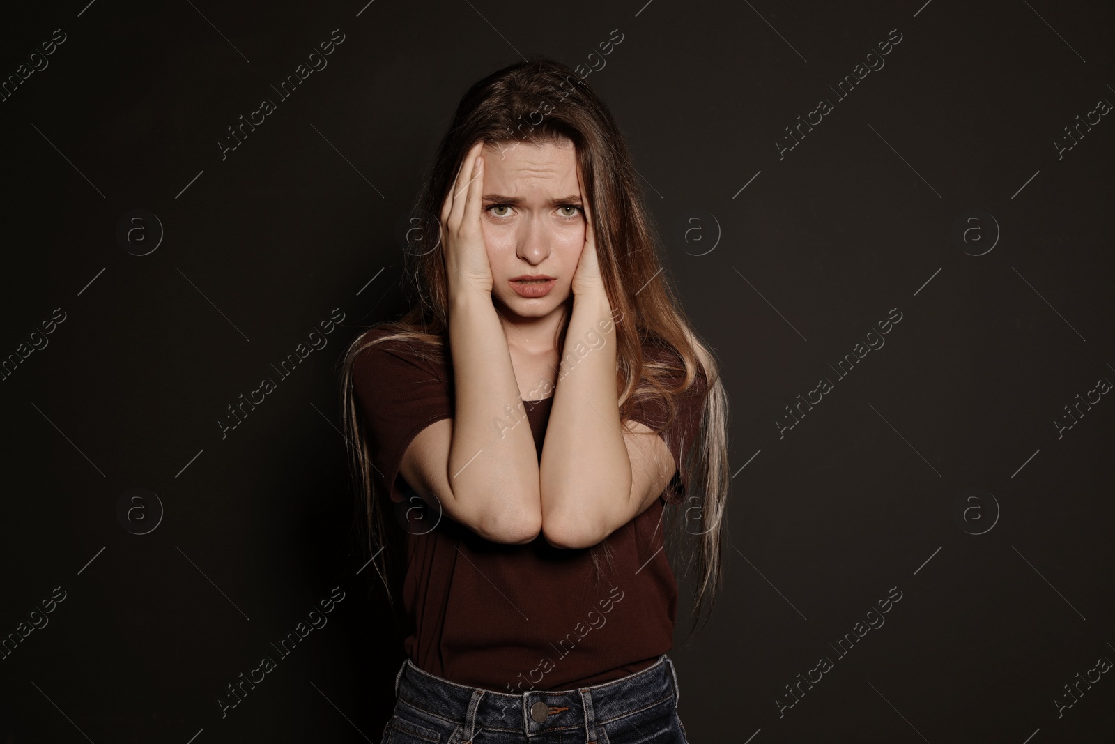 Photo of Portrait of upset young woman on dark background