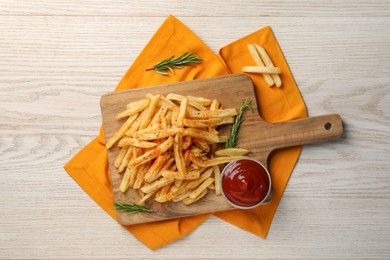 Delicious french fries served with sauce on white wooden table, flat lay