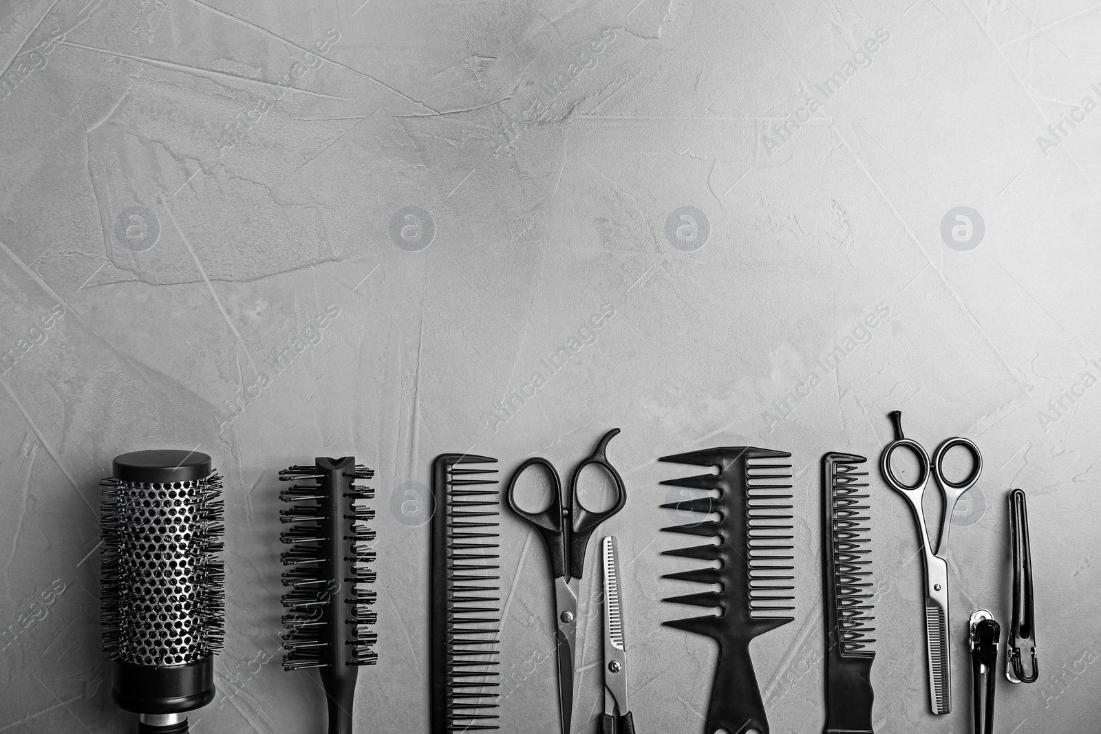 Photo of Flat lay composition with professional hairdresser tools on grey background