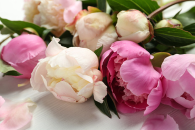 Beautiful peonies on white wooden table, closeup