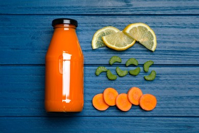 Photo of Healthy carrot juice in bottle and ingredients on blue wooden table, flat lay
