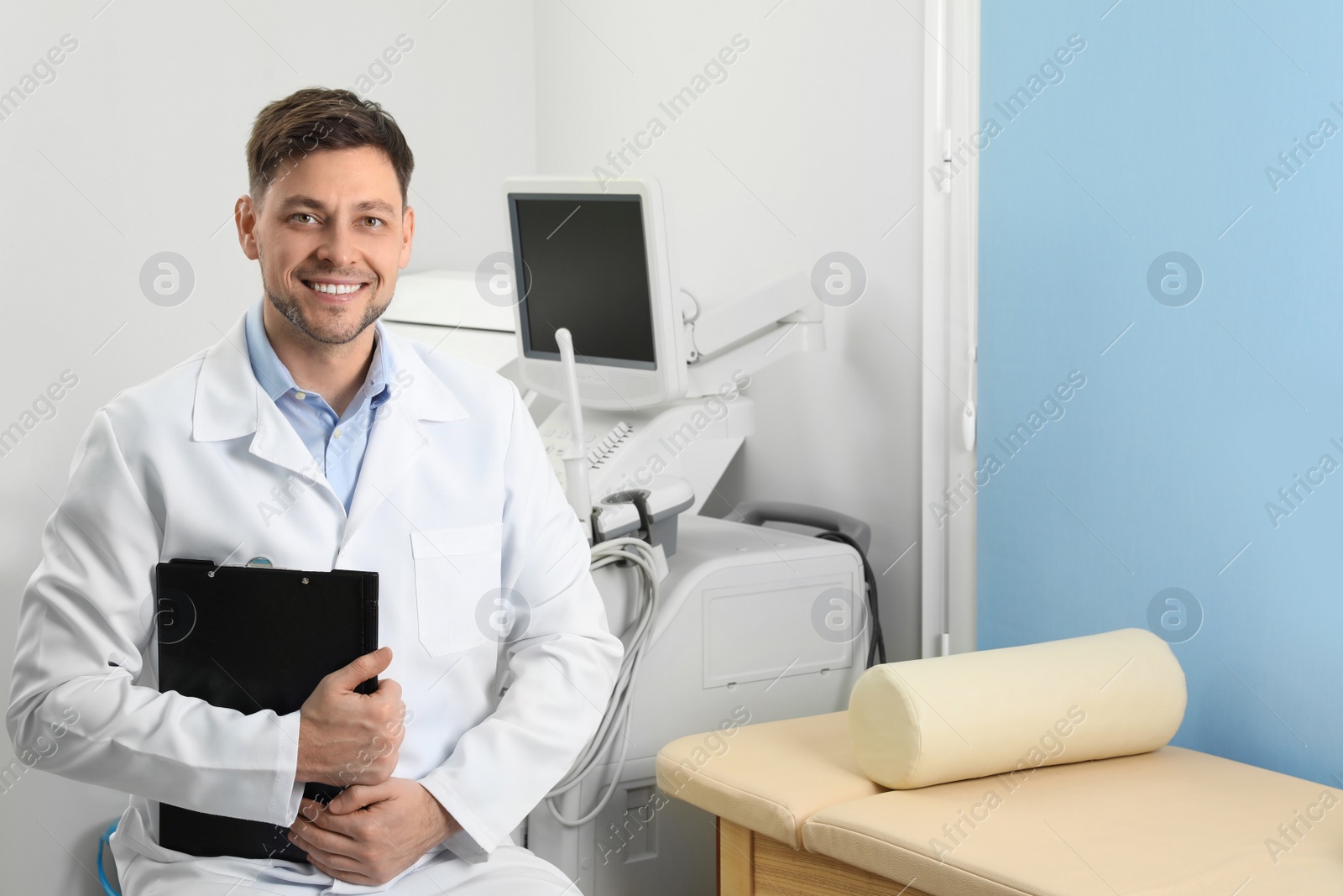 Photo of Professional sonographer with clipboard near modern ultrasound machine in clinic