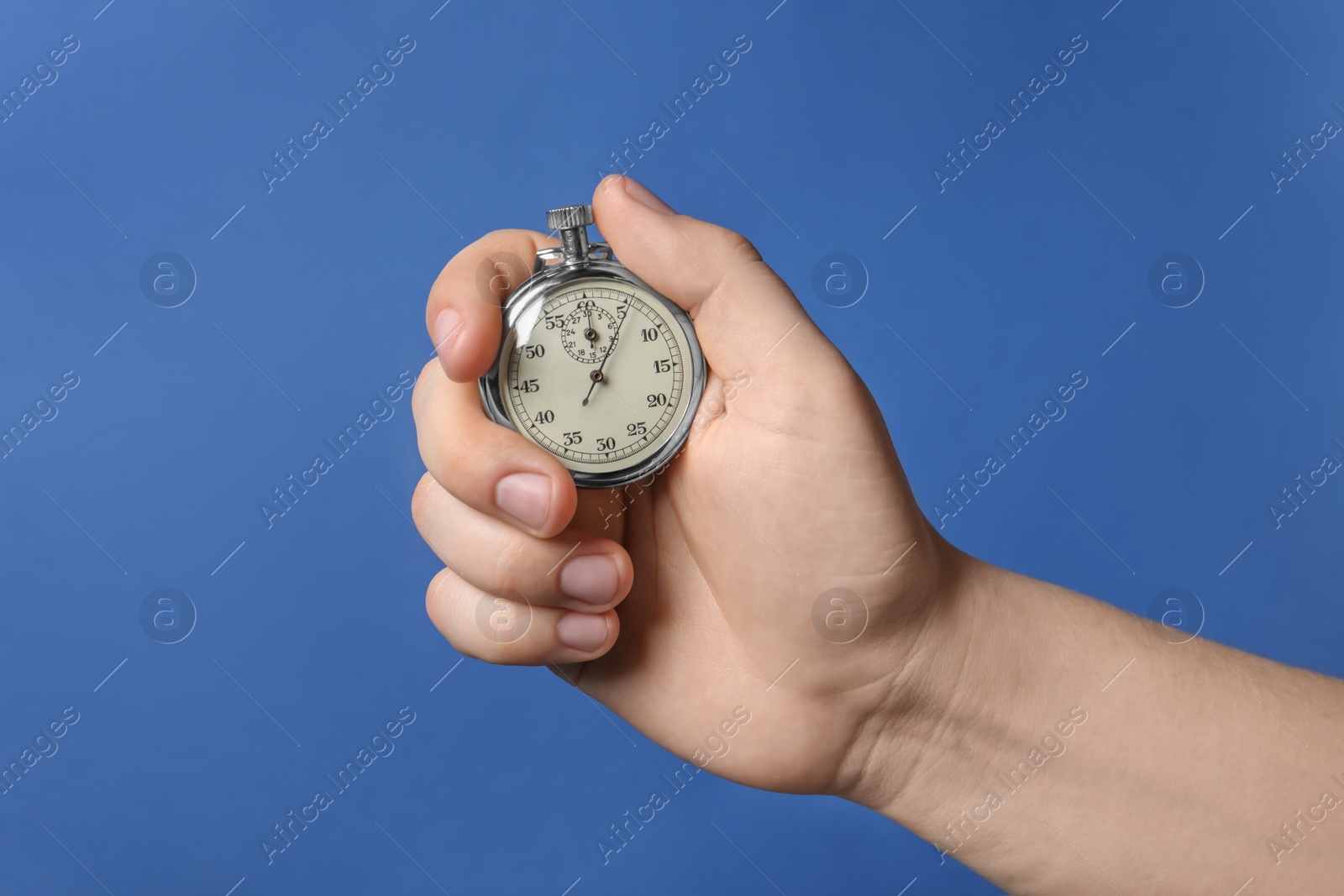 Photo of Man holding vintage timer on blue background, closeup