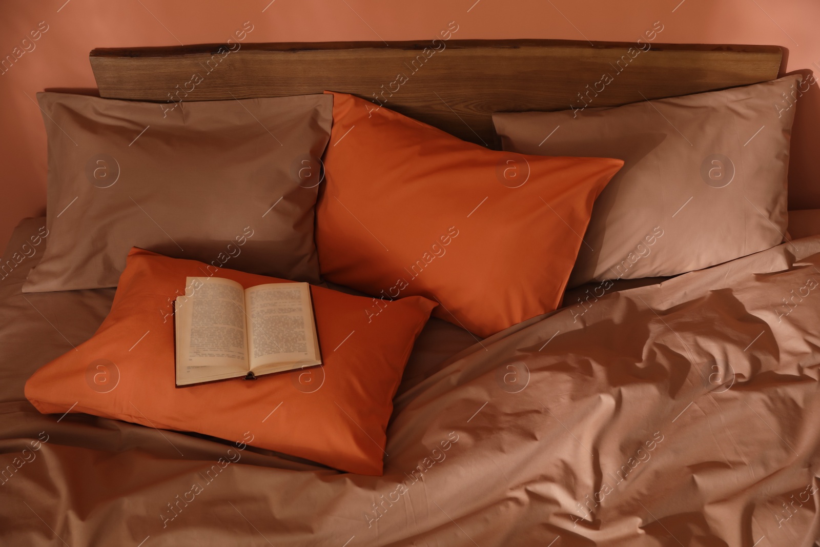 Photo of Book on bed with brown and orange linens