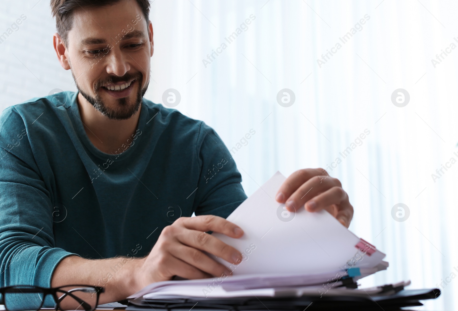 Photo of Man working with documents at table in office. Space for text