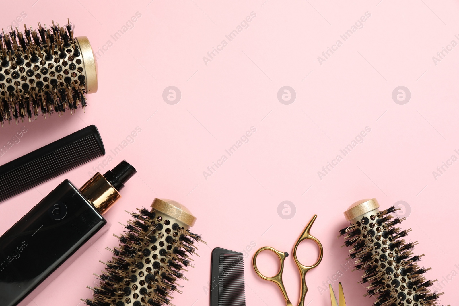 Photo of Professional hair dresser tools on pink background, flat lay. Space for text