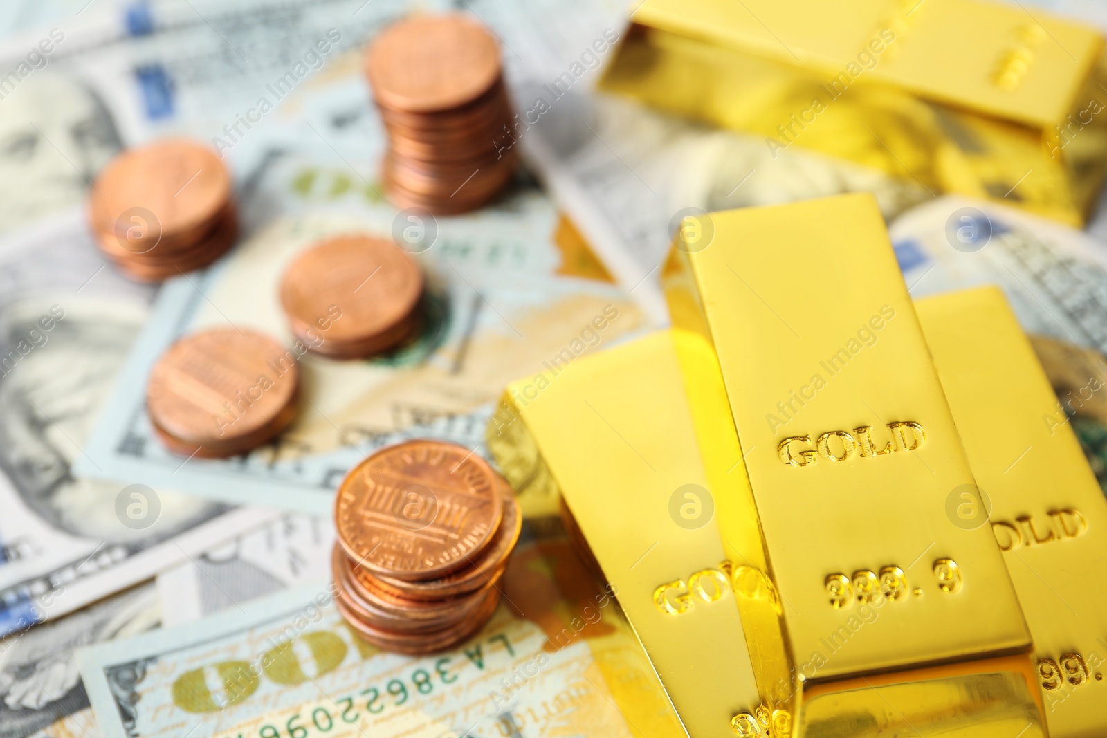 Photo of Shiny gold bars and coins on dollar bills