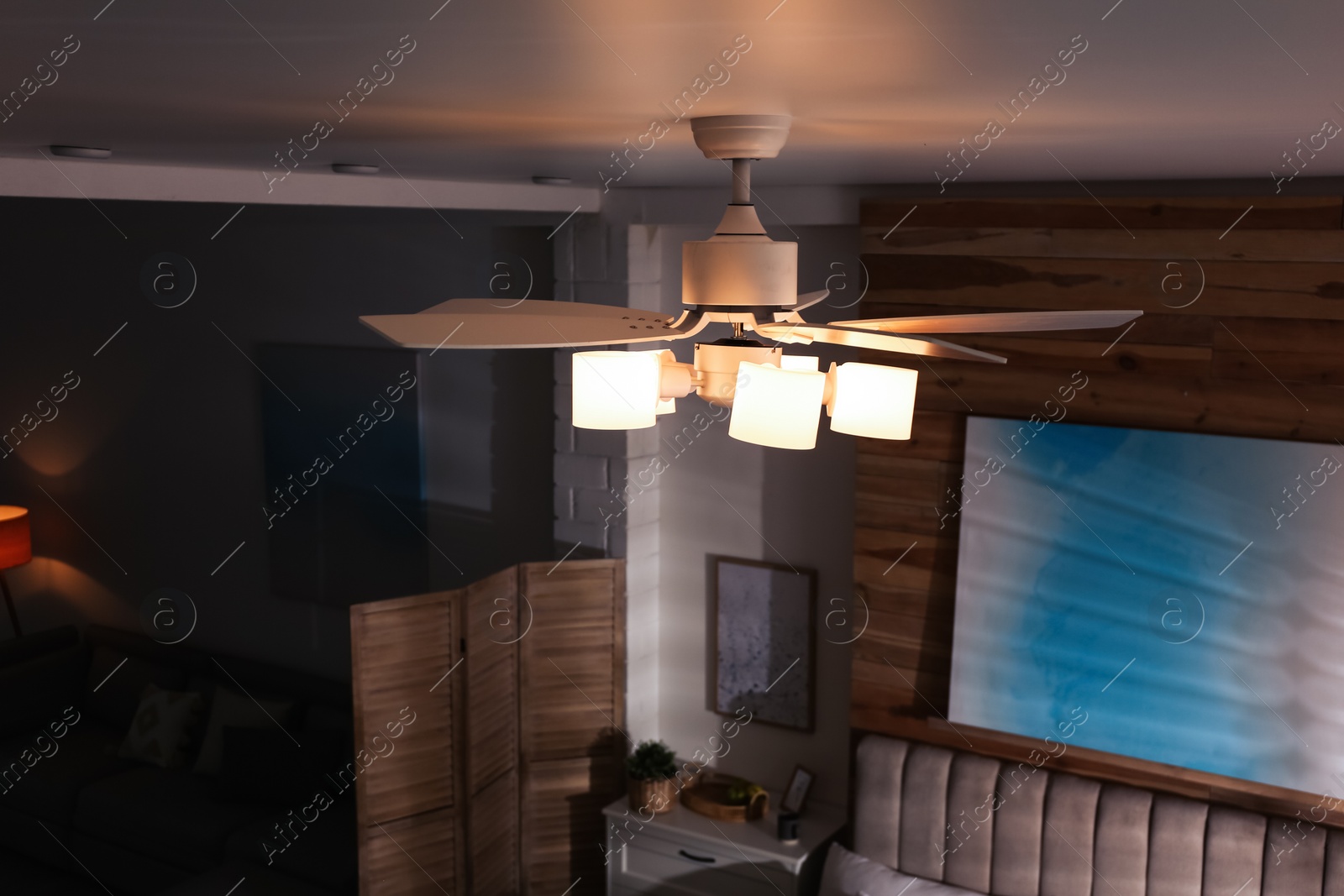 Photo of Modern ceiling fan with lamps in room