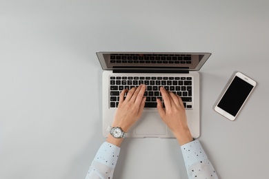 Photo of Woman using modern laptop at table, top view. Space for text