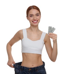 Photo of Slim woman in big jeans with pills on white background. Weight loss