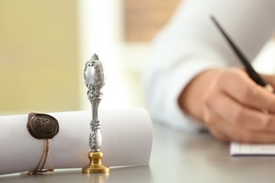 Vintage stamp, sealed scroll and blurred view of notary on background