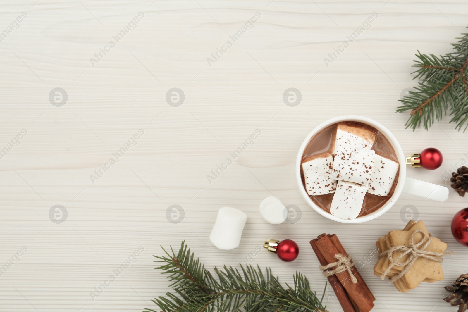 Photo of Flat lay composition with delicious marshmallow cocoa and Christmas decor on white wooden table. Space for text