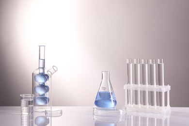 Laboratory analysis. Different glassware on table against light background