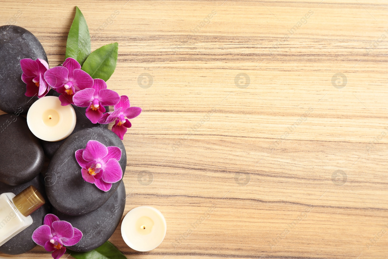 Photo of Flat lay composition with spa stones and orchid flowers on wooden background. Space for text