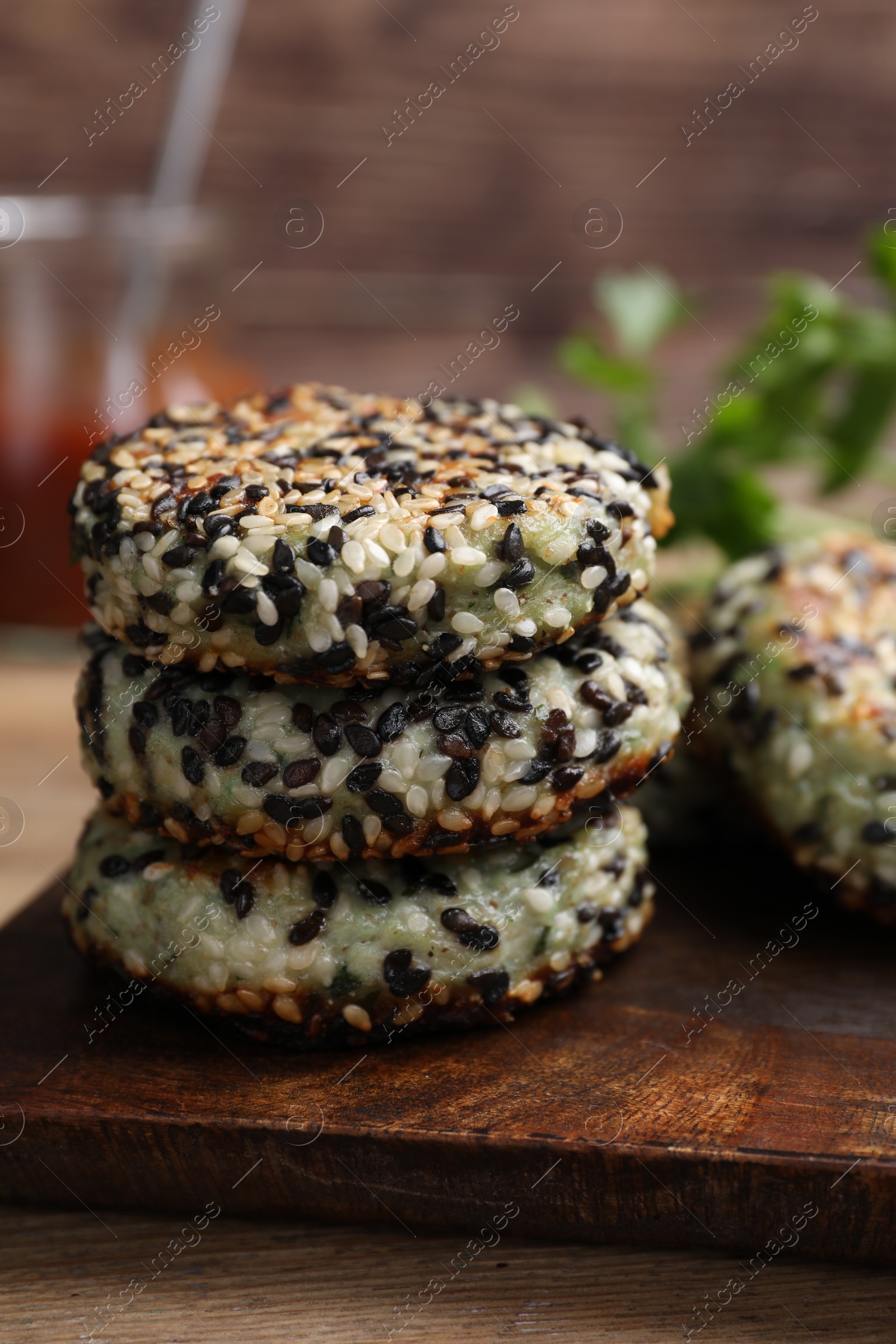 Photo of Delicious vegan cutlets with sesame on wooden table, closeup