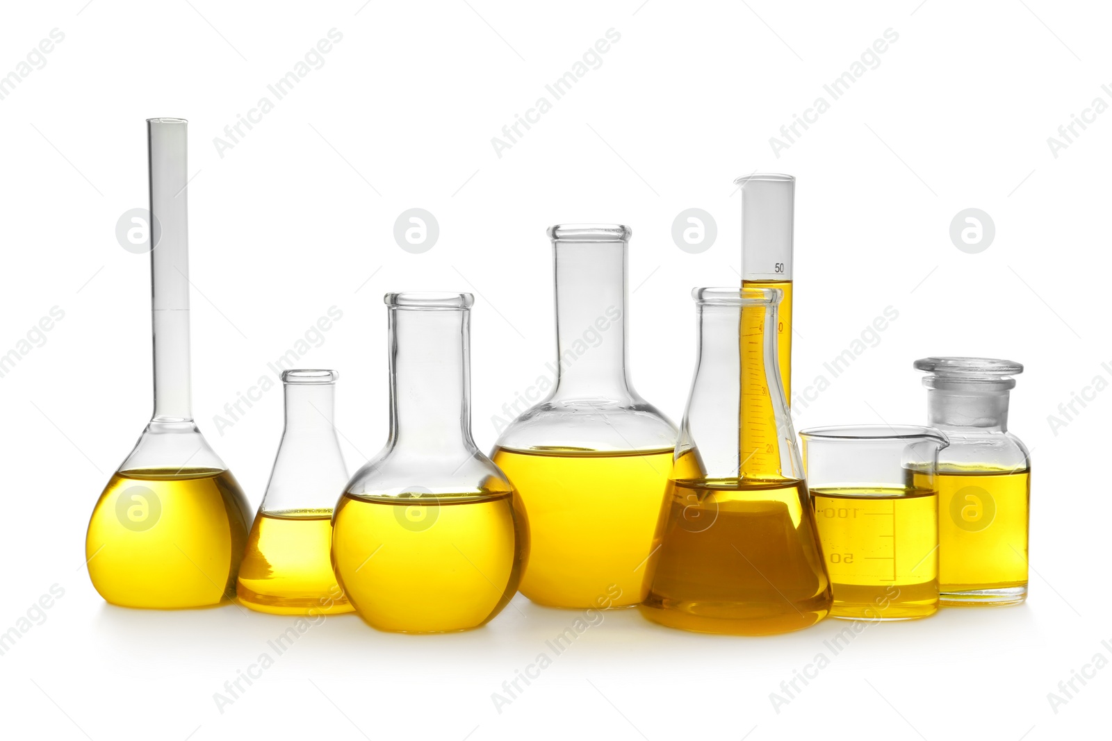 Photo of Laboratory glassware with yellow liquid on white background