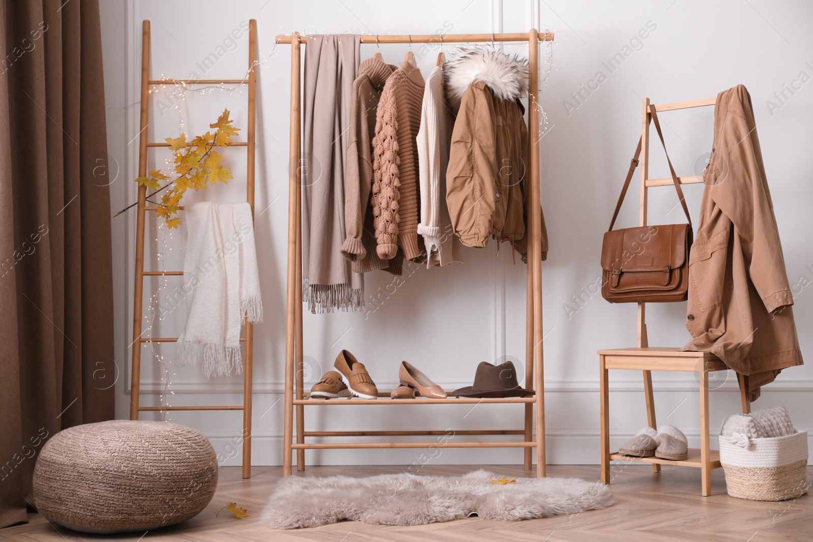 Photo of Rack with stylish warm clothes, shoes and accessories in modern dressing room