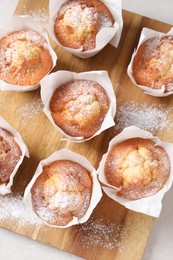 Photo of Delicious muffins on light table, top view