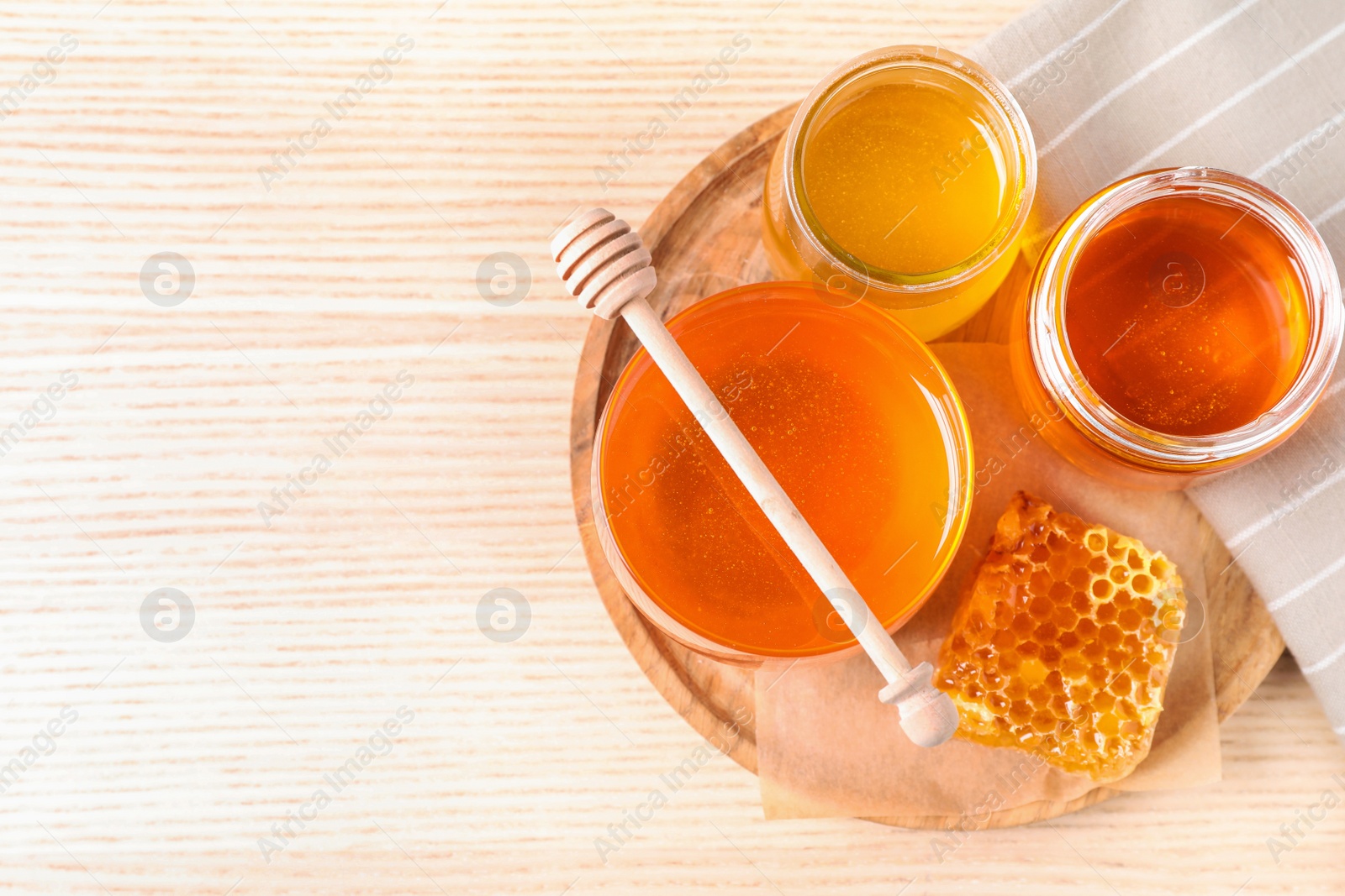 Photo of Tasty honey on white wooden table, top view. Space for text