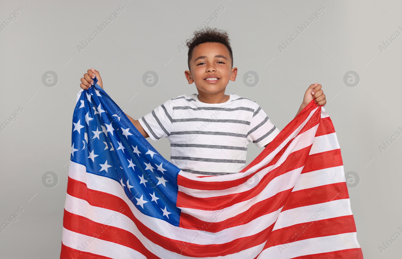 Photo of 4th of July - Independence Day of USA. Happy boy with American flag on light grey background