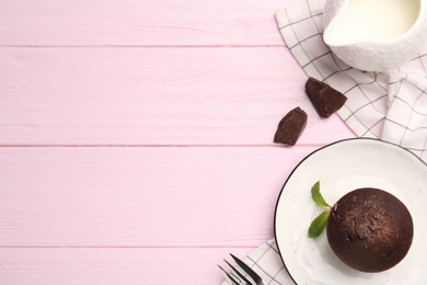 Delicious chocolate muffin served on pink wooden table, flat lay. Space for text