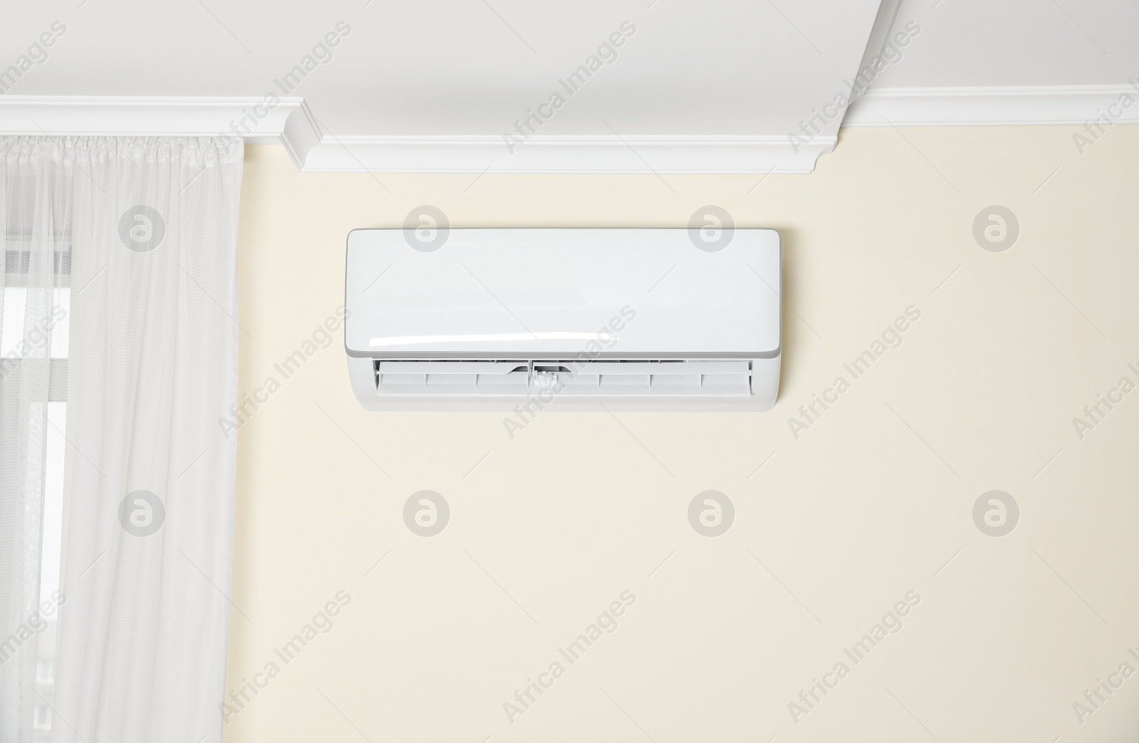 Photo of Modern air conditioner on white wall indoors