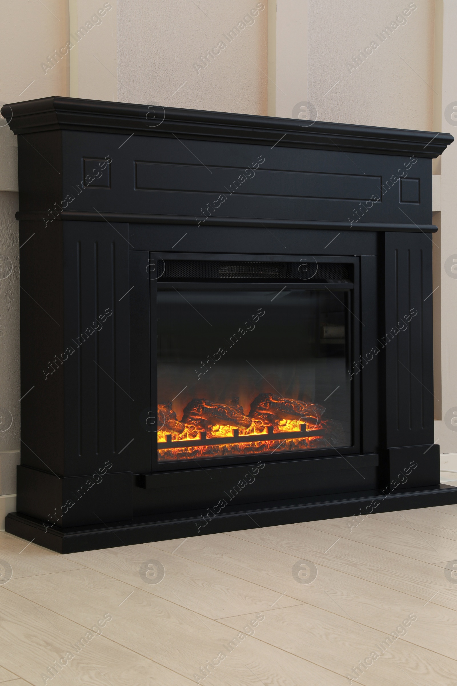 Photo of Modern electric fireplace near light wall indoors