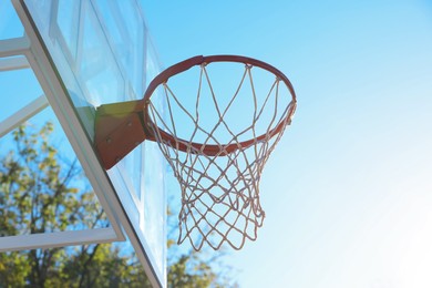 Photo of Basketball hoop with net outdoors on sunny day