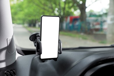 Photo of Car holder with modern mobile phone on windshield of automobile. Mockup for design