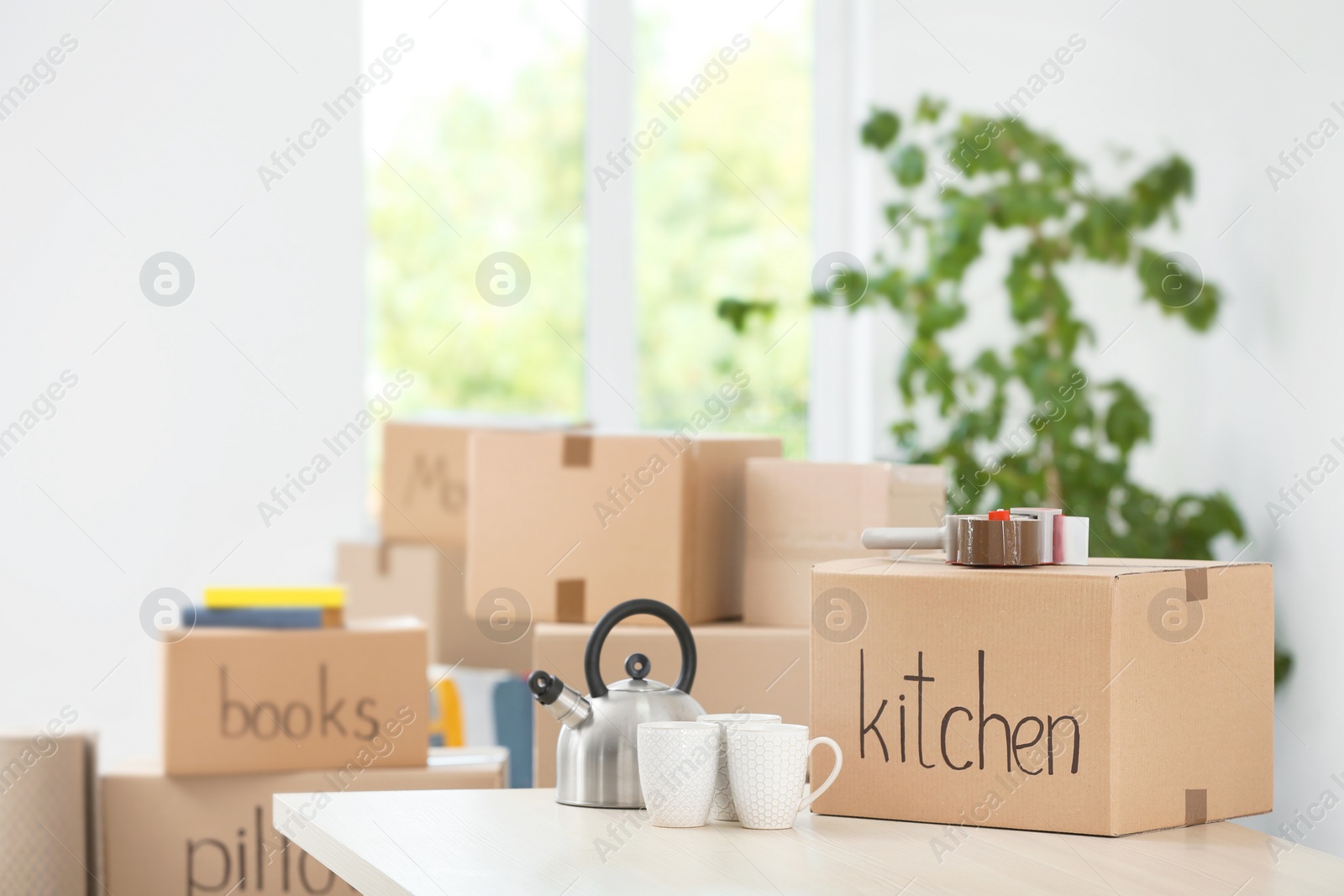 Photo of Moving boxes and household stuff indoors. Space for text