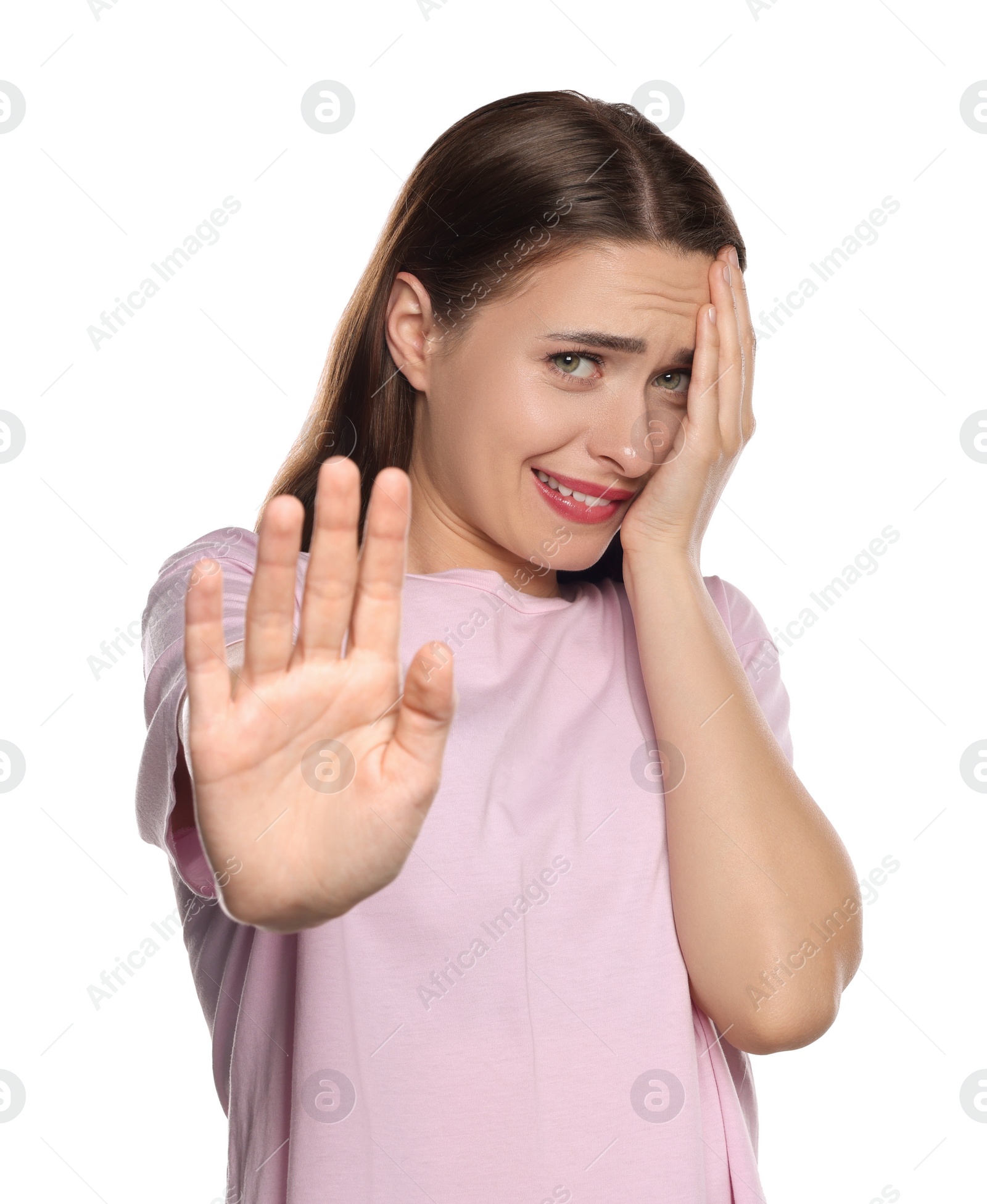 Photo of Embarrassed young woman covering face with hand on white background