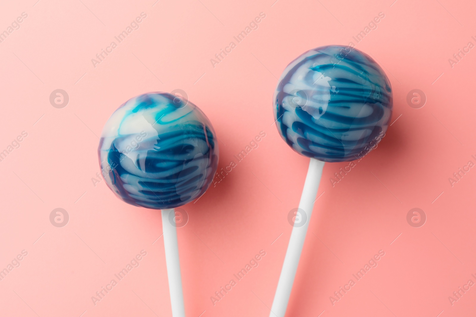 Photo of Tasty lollipops on pink background, flat lay