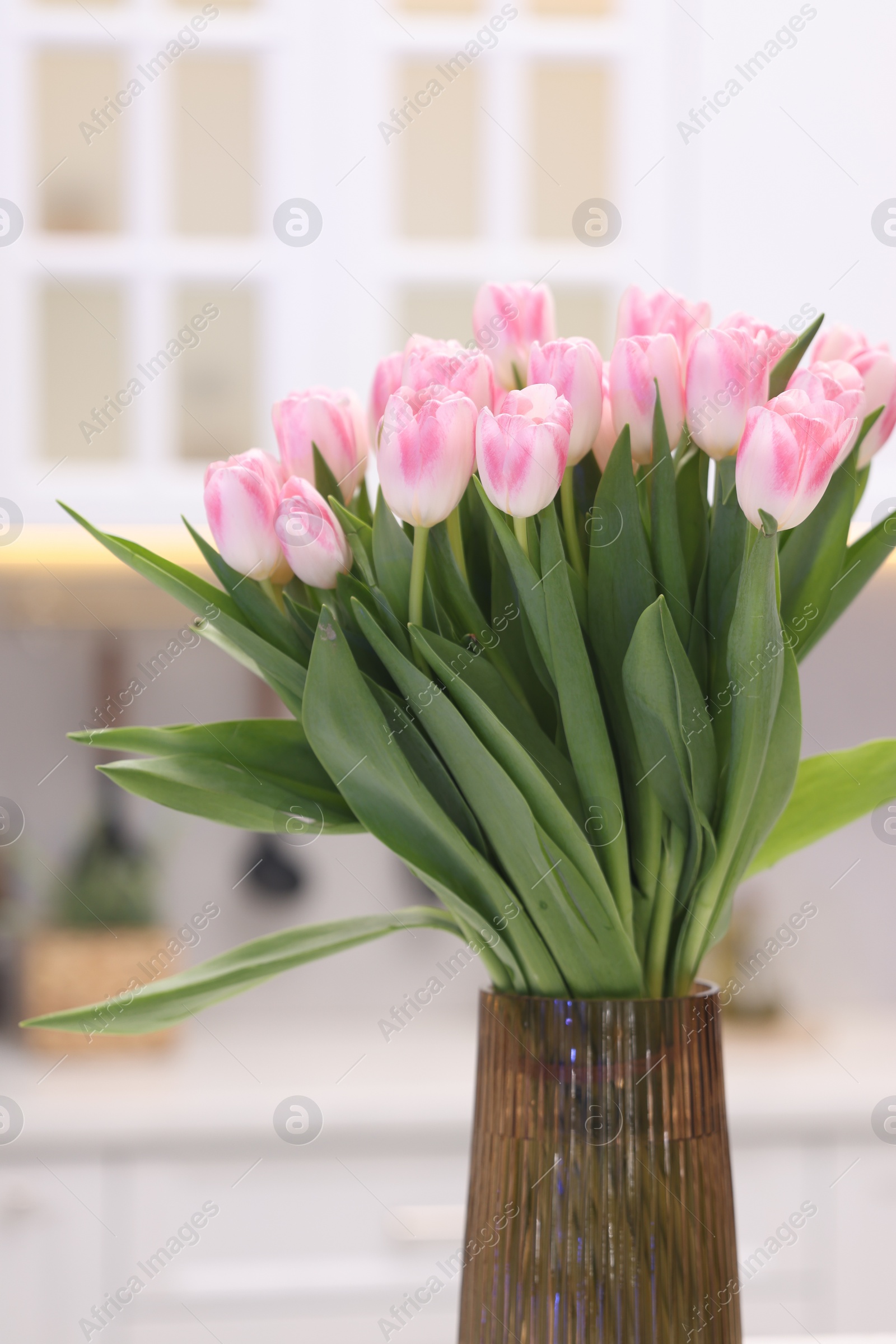 Photo of Beautiful bouquet of fresh pink tulips in kitchen