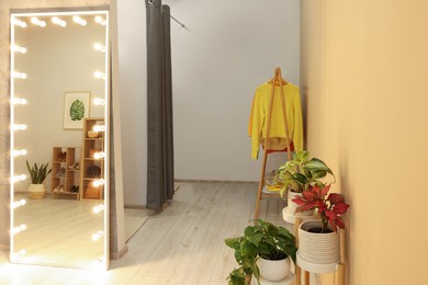 Photo of Stylish dressing room interior with mirror and clothing rack