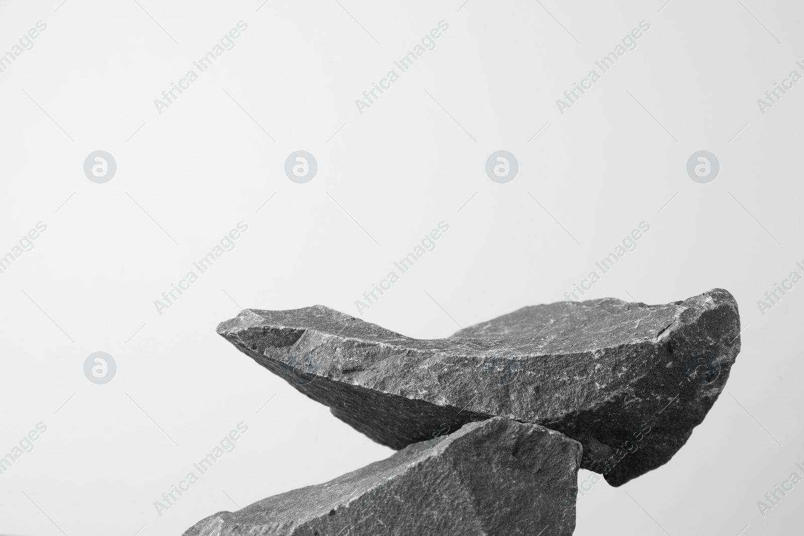 Photo of Presentation for product. Podium made of stones on light grey background. Space for text